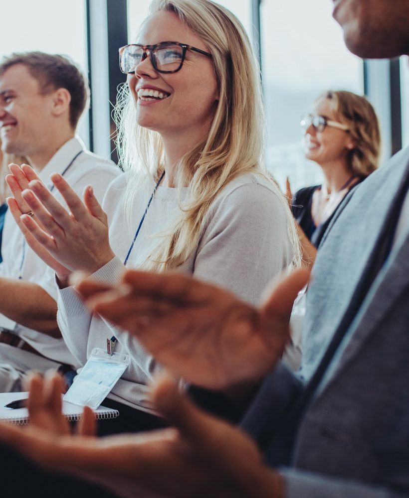 Team of businesspeople clapping hands while having a conference. Business professionals applauding at a seminar.