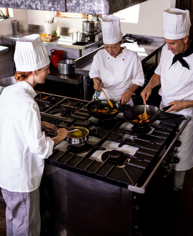 Group of chefs preparing food in kitchen