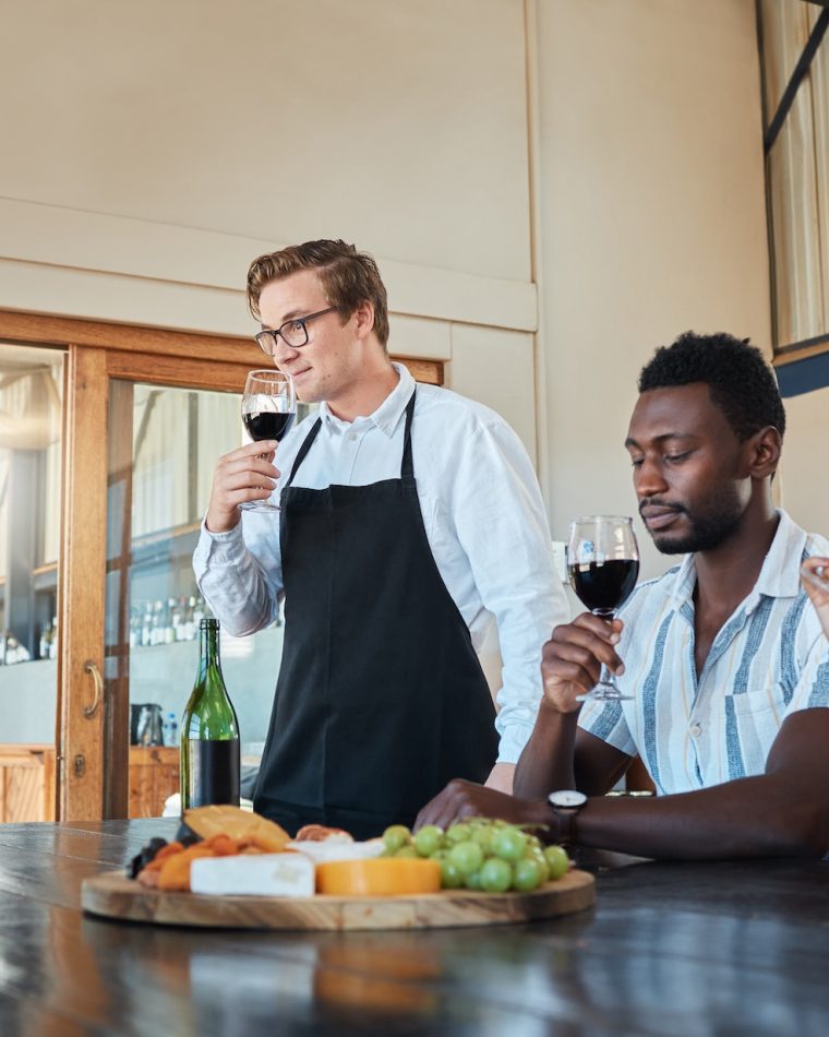 Hospitality, luxury and wine tasting at a restaurant with a professional sommelier teaching how to